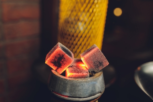 Coals for hookah close-up. Burning coals on the hookah bowl.